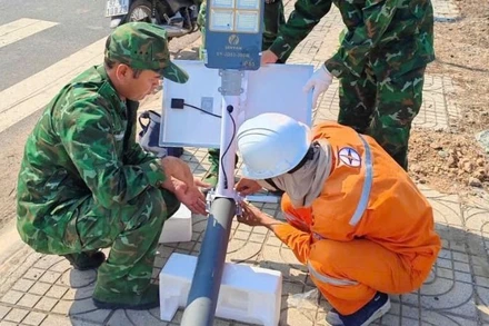 Cán bộ, chiến sĩ Đồn Biên phòng Bo Heng và cán bộ, nhân viên Điện lực thi công công trình.