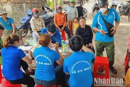 Đại úy Y Giêng Knul cùng các thành viên trong Tổ cải cách hành chính và công nghệ số hướng dẫn người dân kích hoạt định danh mức 2.