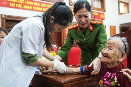 Cán bộ, chiến sĩ Công an và nhân viên Công ty GeneStory tiến hành thu nhận mẫu ADN mẹ liệt sĩ. (Ảnh: Công an tỉnh Đắk Lắk)