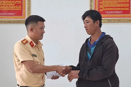 Đại úy Kiều Thanh Hùng, cán bộ Đội Cảnh sát giao thông đường bộ số 2, Phòng Cảnh sát giao thông, Công an tỉnh Đắk Lắk bàn giao số tiền 29 triệu đồng cho anh Phan Ngọc Hùng. (Ảnh: CTV)