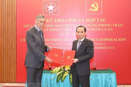 Ông Lê Hoài Trung, Ủy viên Trung ương Đảng, Trưởng Ban Đối ngoại Trung ương và ông Miguel Mejia, Tổng Bí thư Đảng Phong trào cánh tả thống nhất Dominica trao bản thỏa thuận hợp tác giữa hai Đảng. (Ảnh: TTXVN)