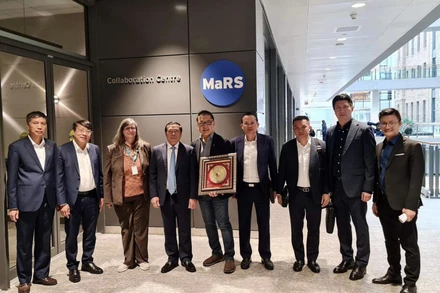 Đồng chí Lại Xuân Môn (thứ 4 bên trái) cùng đoàn công tác chụp ảnh với đại diện Trung tâm MaRS. (Ảnh: TTXVN) 