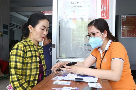 Thành viên Tổ công nghệ số cộng đồng tỉnh Sóc Trăng giúp người dân cài đặt ứng dụng VNeID. (Ảnh: TUẤN PHI)