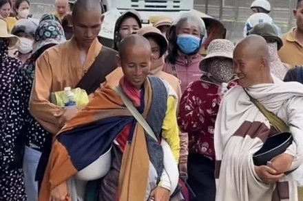 Ông Minh Tuệ (hàng đầu giữa) trong hành trình đi bộ từ Nam ra Bắc luôn thu hút sự hiếu kỳ của nhiều người. (Ảnh: VN/TTXVN)