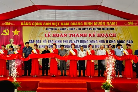 Các đại biểu cắt băng, hoàn thành xây dựng nhà ở cho đồng bào sinh sống trên sông ở huyện Thiệu Hóa lên bờ định cư.