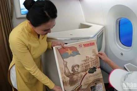 Hành khách trên chuyến bay bất ngờ nhận được món quà ý nghĩa từ Vietnam Airlines - tờ phụ san đặc biệt của báo Nhân Dân về sự kiện 30/4.