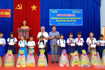 Đại diện đoàn công tác của Văn phòng Thành ủy Thành phố Hồ Chí Minh trao quà cho học sinh có hoàn cảnh khó khăn tại U Minh vào sáng 21/3.