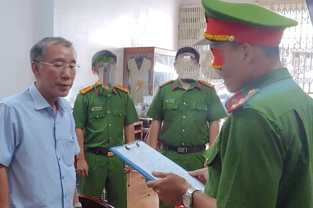 Lực lượng chức năng đọc lệnh bắt tạm giam ông Tô Quang Phúc (bìa trái), cựu Giám đốc Quỹ đầu tư phát triển tỉnh Cà Mau (ảnh Công an cung cấp). 