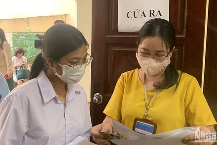 Giám thị gọi thí sinh vào phòng thi theo số báo danh tại điểm thi Trường đại học Sư phạm Hà Nội. (Ảnh: THÚY QUỲNH)