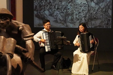 Hai nghệ sĩ accordion Nguyễn Quỳnh Chi và Vũ Việt Hưng biểu diễn trong không gian trưng bày các tác phẩm mỹ thuật về Chiến dịch Điện Biên Phủ tại Bảo tàng Mỹ thuật Việt Nam. (Ảnh: THANH BÌNH) 