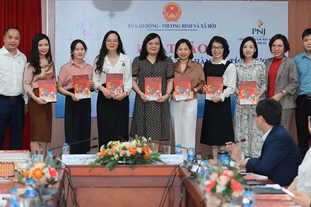 Ban tổ chức trao tặng tài liệu “Hỗ trợ hành vi tích cực cho trẻ có rối loạn phổ tự kỷ” cho cán bộ, giáo viên các trung tâm can thiệp. (Ảnh: NFVC)