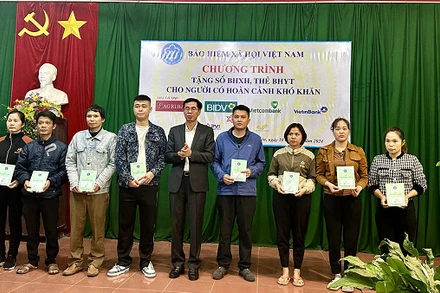 Phó Tổng Giám đốc Bảo hiểm xã hội Việt Nam Đào Việt Ánh trao thẻ bảo hiểm y tế, sổ bảo hiểm xã hội cho người dân khó khăn ở huyện Tân Yên, Bắc Giang. (Ảnh: VSS)