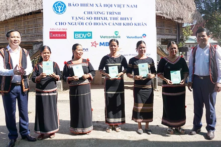 Phó Tổng Giám đốc Bảo hiểm xã hội Việt Nam Chu Mạnh Sinh trao sổ bảo hiểm xã hội, thẻ bảo hiểm y tế tặng người dân xã Đăk La, huyện Đăk Hà, Kon Tum. (Ảnh: KSS)