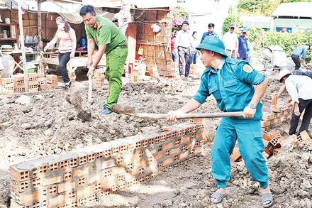 Lực lượng vũ trang cùng các đoàn thể chính trị xã Huyền Hội, huyện Càng Long, tỉnh Trà Vinh, hỗ trợ người dân xây nhà. (Ảnh: KHỞI - GIANG)