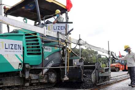 Nhà thầu tiến hành thảm nhựa lớp đầu tiên tại gói thầu số 21, thuộc dự án thành phần 1, đường cao tốc Biên Hòa-Vũng Tàu, đoạn qua tỉnh Đồng Nai. (Ảnh Công Phong)