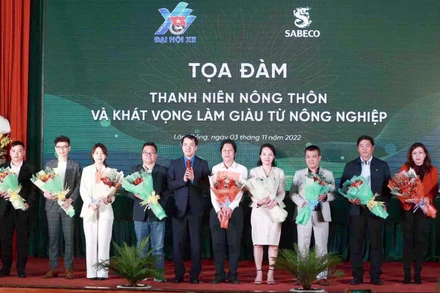 Ban Tổ chức tặng hoa cho các đại biểu, thanh niên nhận giải thưởng Lương Định Của điển hình qua các thời kỳ tham gia tọa đàm.