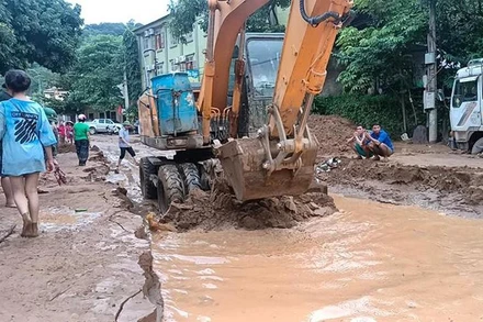 Lực lượng chức năng san gạt bùn đất do lũ quét để sớm thông quốc lộ 7, đoạn qua thị trấn Mường Xén (Kỳ Sơn).