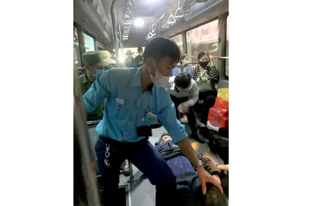 Nhân viên xe buýt đưa người bị thương lên xe để chở đến bệnh viện cấp cứu.