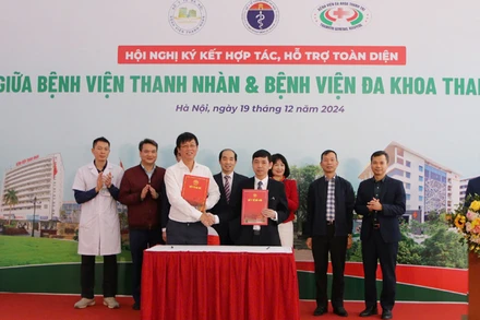 Lãnh đạo hai bệnh viện trao đổi biên bản ký kết giữa hai đơn vị.