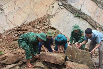 Cán bộ chiến sĩ Đồn Biên phòng Mường Ải phối hợp với các lực lượng và nhân dân khắc phục tình trạng đá sạt lở gây ách tắc giao thông, mất an toàn trên tuyến đường qua địa bàn.