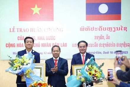 Ông Khamlay Sipraseuth, Ủy viên Trung ương Đảng, Phó Chủ tịch thường trực Ủy ban Trung ương Mặt trận Lào Xây dựng đất nước trao tặng Huân chương Itxala (Tự do) hạng III cho Thứ trưởng Bộ Nội vụ Vũ Chiến Thắng (bên phải) và nguyên Thứ trưởng, nguyên Phó Chủ nhiệm Ủy ban Dân tộc Hoàng Xuân Lương (bên trái). (Ảnh: Văn Điệp/TTXVN)