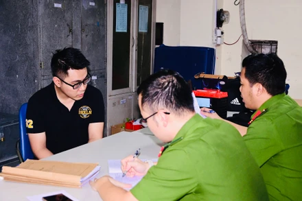 Nguyễn Tường Lâm (áo đen) bị bắt giữ tại cơ quan công an.