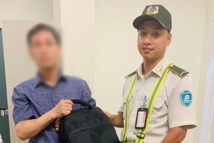 Anh Nguyễn Thanh Bình, nhân viên an ninh Cảng Hàng không quốc tế Nội Bài trao trả chiếc ba lô cho chủ nhân.