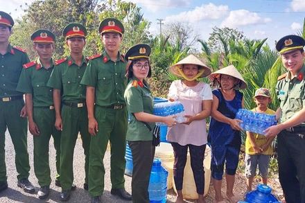 Công an Sóc Trăng tặng nước uống đóng chai cho người dân.