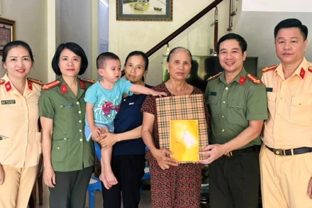 Đại diện đoàn công tác trao tặng quà cho trẻ em cùng gia đình.