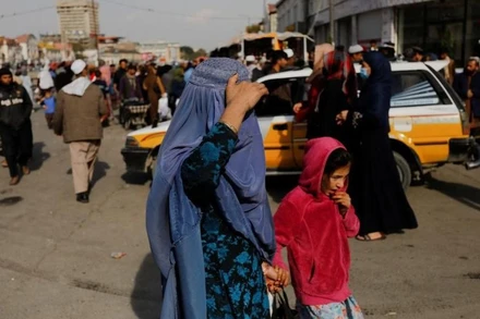 Một phụ nữ và trẻ em gái đi bộ trên một con phố ở Kabul, Afghanistan ngày 9/11/2022. (Ảnh: Reuters)