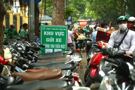 Điểm trông giữ xe máy hạn chế dùng tiền mặt trên phố Phủ Doãn.