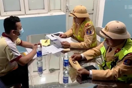 Cảnh sát giao thông làm việc với người vi phạm trật tự an toàn giao thông.