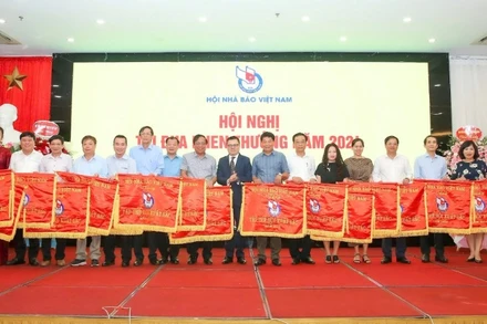 Chủ tịch Hội Nhà báo Việt Nam Lê Quốc Minh trao Cờ thi đua tặng tập thể có thành tích xuất sắc.