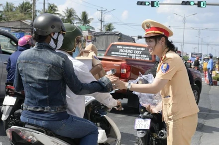 Cảnh sát giao thông tỉnh Tiền Giang tặng nước cho người dân dưới tiết trời nắng nóng.
