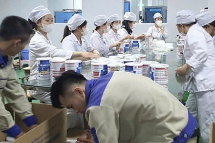 Công nhân đóng hộp thành phẩm sữa giả tại cơ sở sản xuất chuẩn bị đưa ra thị trường tiêu thụ. (Ảnh: CAND)