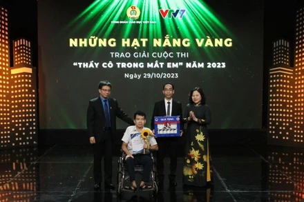 Thứ trưởng Giáo dục Ngô Thị Minh và Chủ tịch Công đoàn Giáo dục Việt Nam Nguyễn Ngọc Ân trao giải đặc biệt tặng em Nguyễn Minh Kiệt, Trường Trung học cơ sở Chương Dương, Hoàn Kiếm, Hà Nội và thầy giáo của mình.