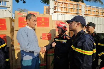 Đại tá Nguyễn Minh Khương trao hàng cứu trợ cho Vụ trưởng Vụ Quản lý thiên tai, Bộ Phúc lợi xã hội, Cứu trợ và Tái định cư Myanmar. (Ảnh: Lê Hoàng gửi về từ Myanmar)