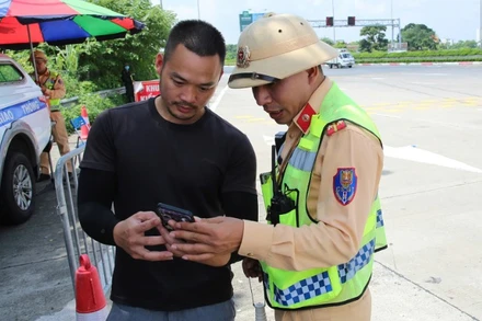 Cảnh sát giao thông kiểm tra giấy phép lái xe của chủ phương tiện qua ứng dụng VNeID.