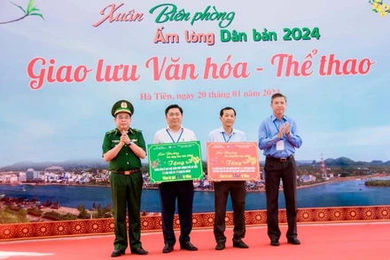 Thiếu tướng Phùng Quốc Tuấn, Phó Chính ủy Bộ đội biên phòng và Phó Chủ tịch Ủy ban Nhân dân tỉnh Kiên Giang Nguyễn Lưu Trung (bên phải) trao biển tượng trưng tặng hiện vật tặng nhân dân, học sinh khu vực biên giới thành phố Hà Tiên, trị giá hơn 2,1 tỉ đồng. Ảnh: Đăng Bảy
