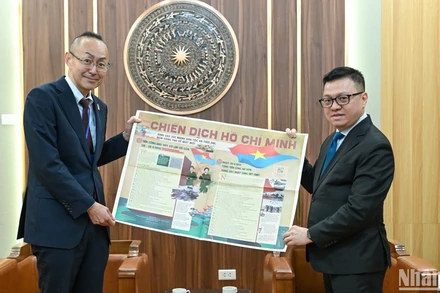 Tổng Biên tập Lê Quốc Minh giới thiệu phụ san đặc biệt của Báo Nhân Dân kỷ niệm 50 năm Ngày Giải phóng miền nam, Thống nhất đất nước tới Trưởng Đại diện JICA tại Việt Nam, ông Kobayashi Yosuke. (Ảnh: BÙI GIANG)