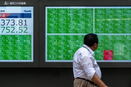 Một người đi bộ ngang qua màn hình hiển thị thông tin thị trường chứng khoán tại Tokyo, Nhật Bản, ngày 2/8/2024. (Ảnh minh họa: Tân Hoa xã)
