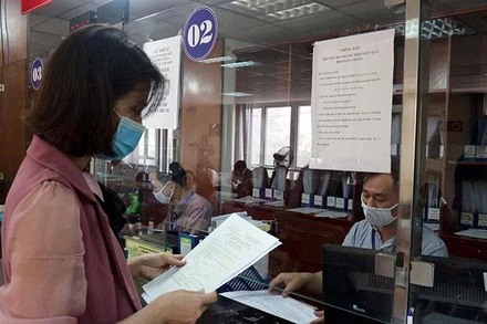 Doanh nghiệp làm thủ tục đăng ký kinh doanh tại Bộ phận một cửa Sở Kế hoạch và Đầu tư Hà Nội. (Ảnh: Mạnh Khánh)