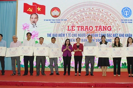 Lãnh đạo tỉnh Sóc Trăng trao bảng tượng trưng tặng thẻ bảo hiểm y tế cho người có hoàn cảnh đặc biệt khó khăn. 