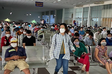 Hành khách chờ đến lượt mua vé tàu Tết sau khi đã lấy số thứ tự tại ga Sài Gòn.