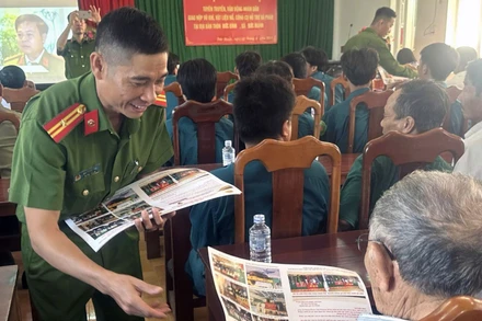 Công an tỉnh Đắk Nông phát tờ rơi tuyên truyền, phổ biến pháp luật cho người dân. (Ảnh: HOÀNG OANH)