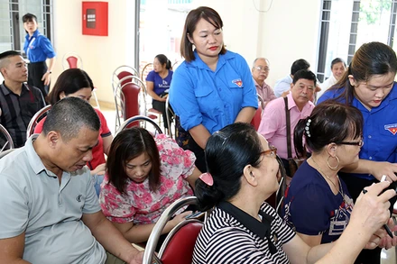 Các thành viên tổ công nghệ số cộng đồng phường Minh Xuân, thành phố Tuyên Quang hướng dẫn người dân cài đặt ứng dụng số.