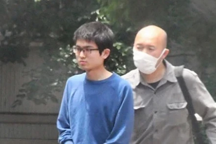 Cảnh sát áp giải đối tượng Nao Sato (áo xanh). (Nguồn: Asahi)