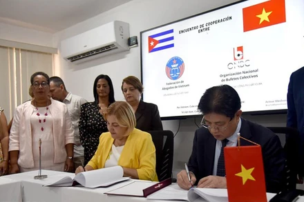 Chủ tịch Liên đoàn Luật sư Việt Nam Đỗ Ngọc Thịnh và Chủ tịch Tổ chức các Công ty Luật Cuba Lilia María Hernández Doejo ký thỏa thuận hợp tác. (Ảnh: TTXVN)