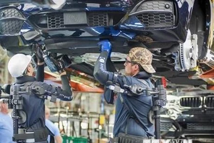 Công nhân làm việc trên dây chuyền sản xuất xe ô tô của Hãng BMW (Đức). (Ảnh: DW/TTXVN)