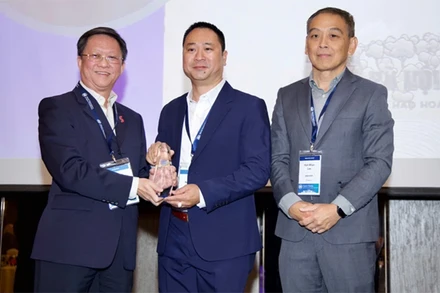 Nhà báo Trần Ngọc Long (giữa) đại diện Báo Điện tử VietnamPlus nhận giải thưởng tại Malaysia. (Ảnh: Vietnam+)